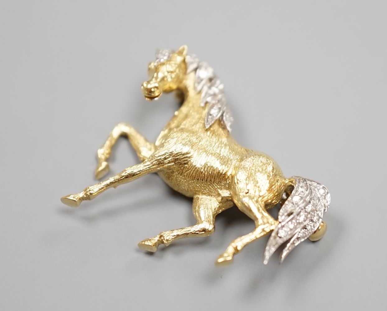 A modern 18ct gold and diamond chip set horse brooch, 29mm, gross weight 7.4 grams.